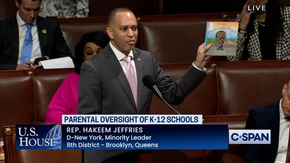 Leader Jeffries holding up a copy of a children's book titled "I am Martin Luther King Jr."