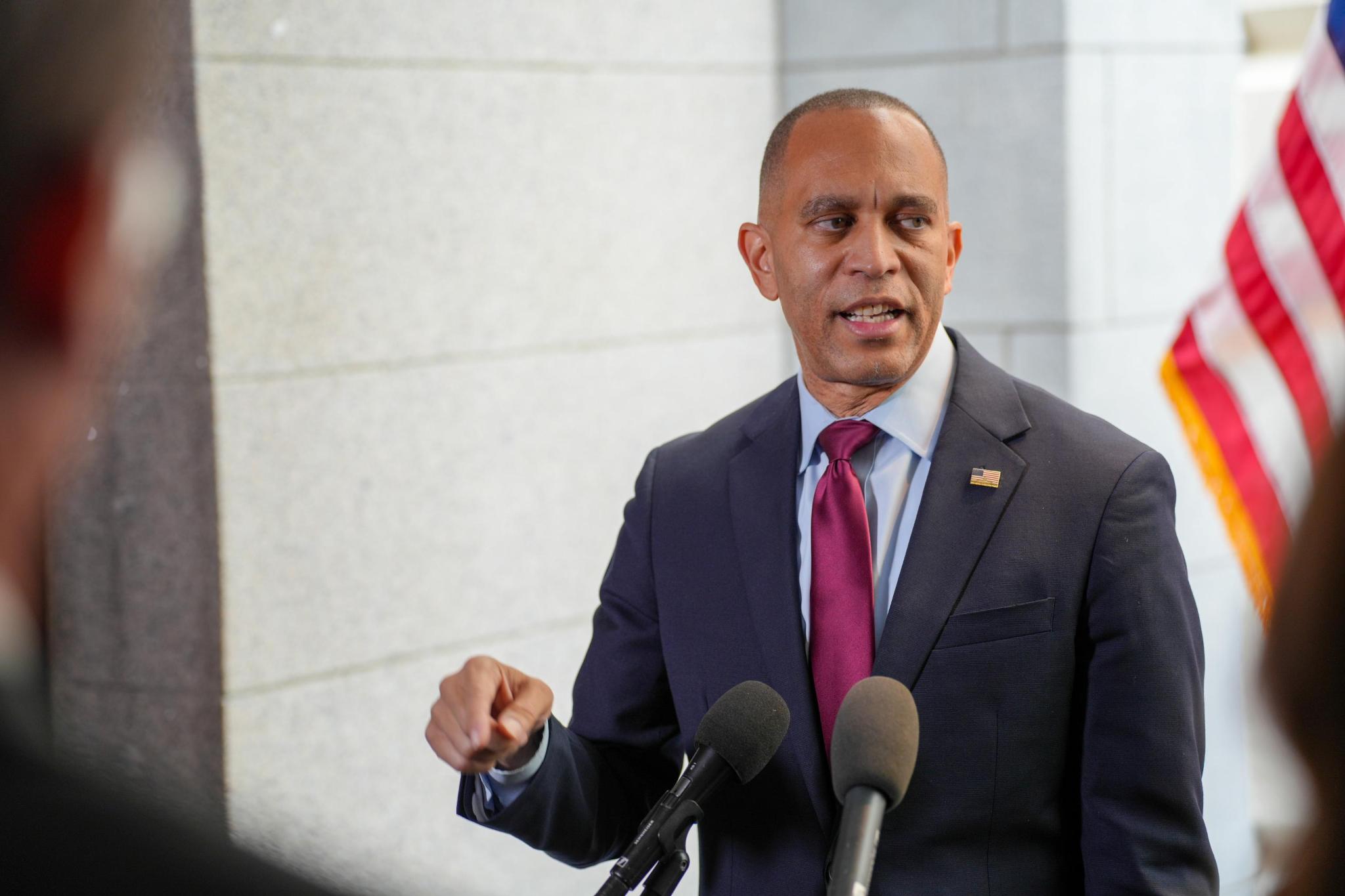 Leader Jeffries speaking at press conference in front of American flag