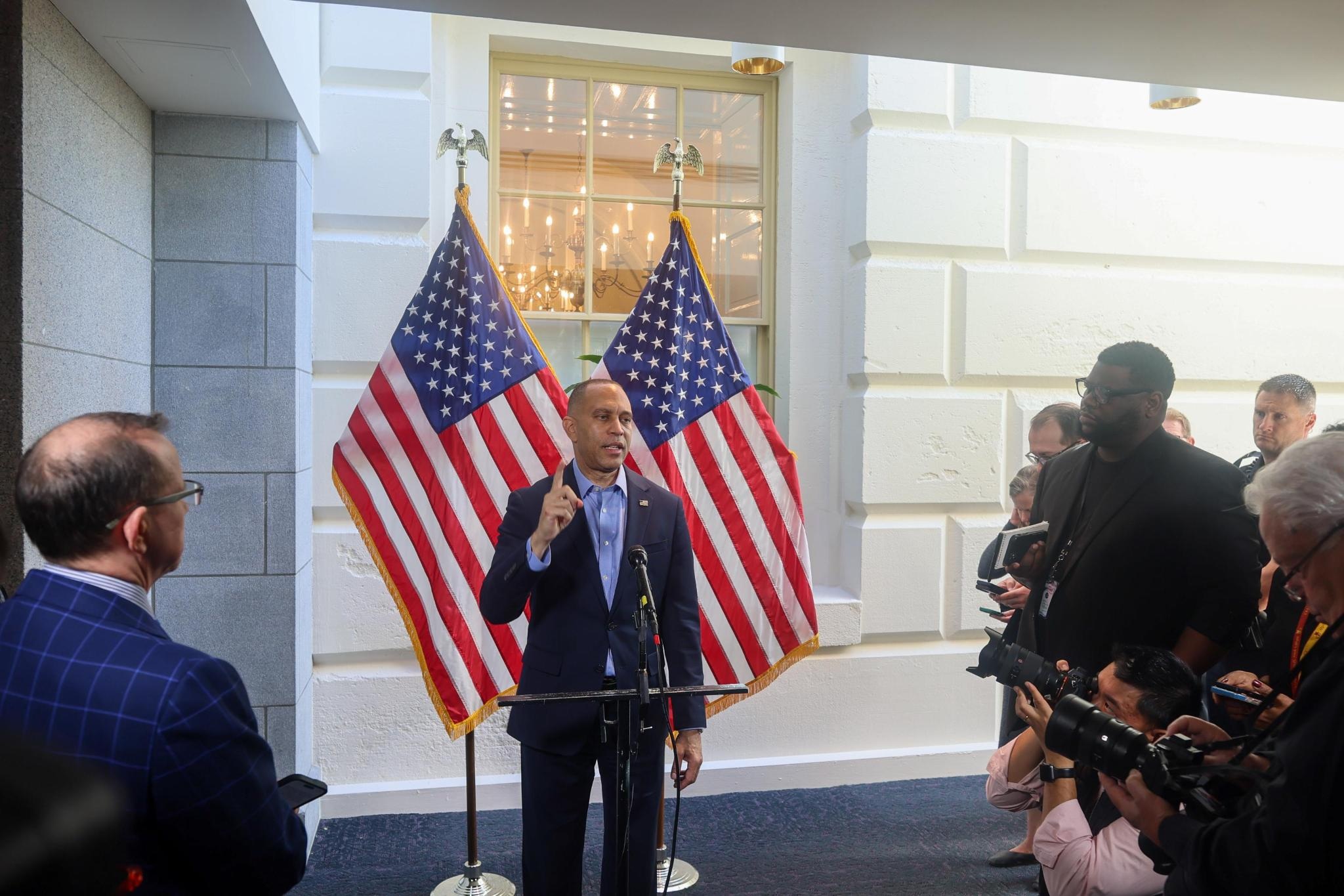 Leader Jeffries speaking at weekly press conference in front of two American flags