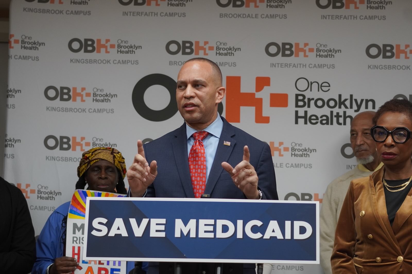 Leader Jeffries speaking from behind a podium with a sign that reads "Save Medicaid"