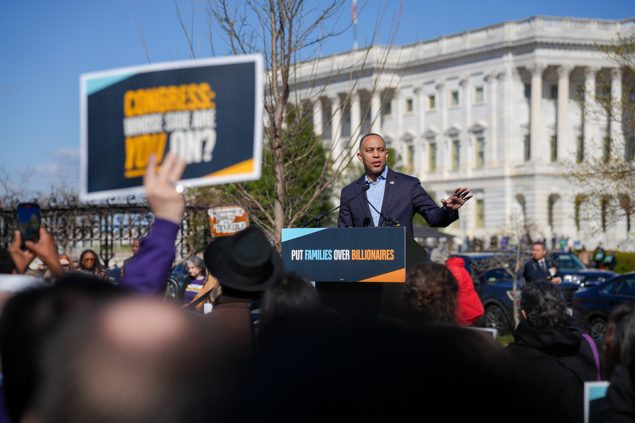 Leader Jeffries delivering remarks at a rally behind a podium sign reading "Put Families Over Billionaires"