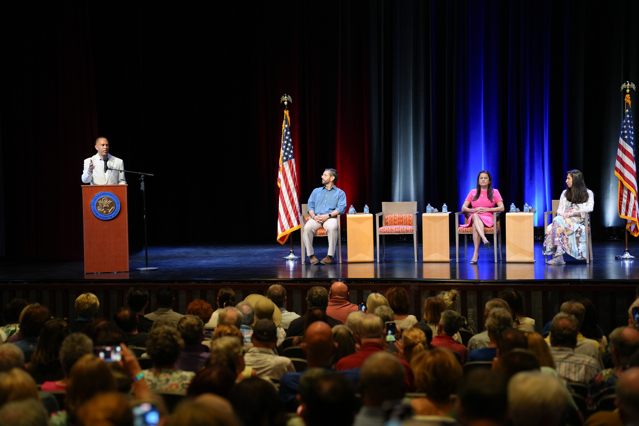 Leader Jeffries speaking behind podium. Seated on stage left are Rep. Raul Ruiz (CA-25), Steering and Policy Co-Chair Rep. Nanette Barragán (CA-44) and Rep. Teresa Leger Fernández (NM-03)
