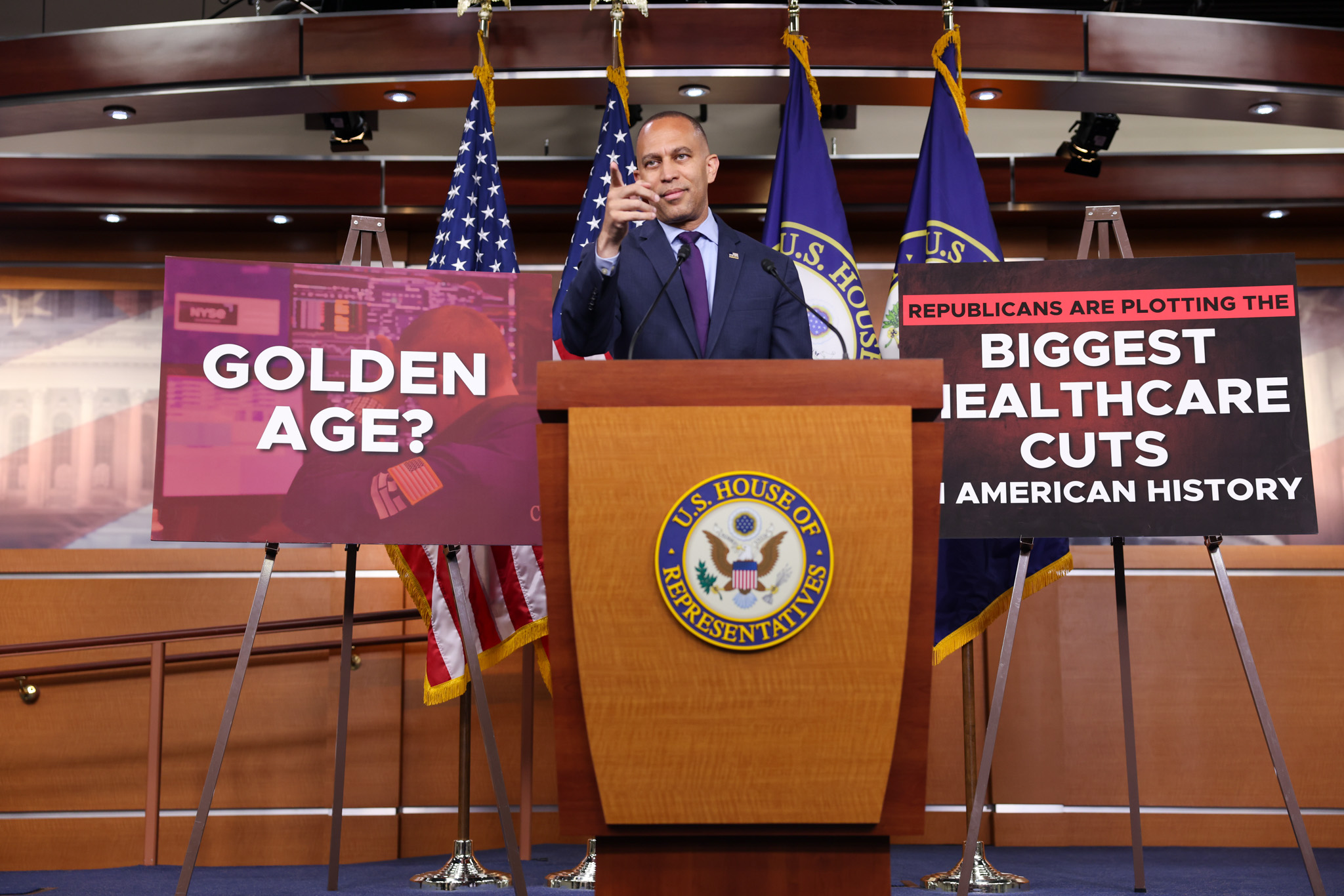 Leader Jeffries Speaking at Weekly Press Conference in between posters reading "Golden Age?" and "Republicans are Plotting the Biggest Healthcare Cuts in American History"