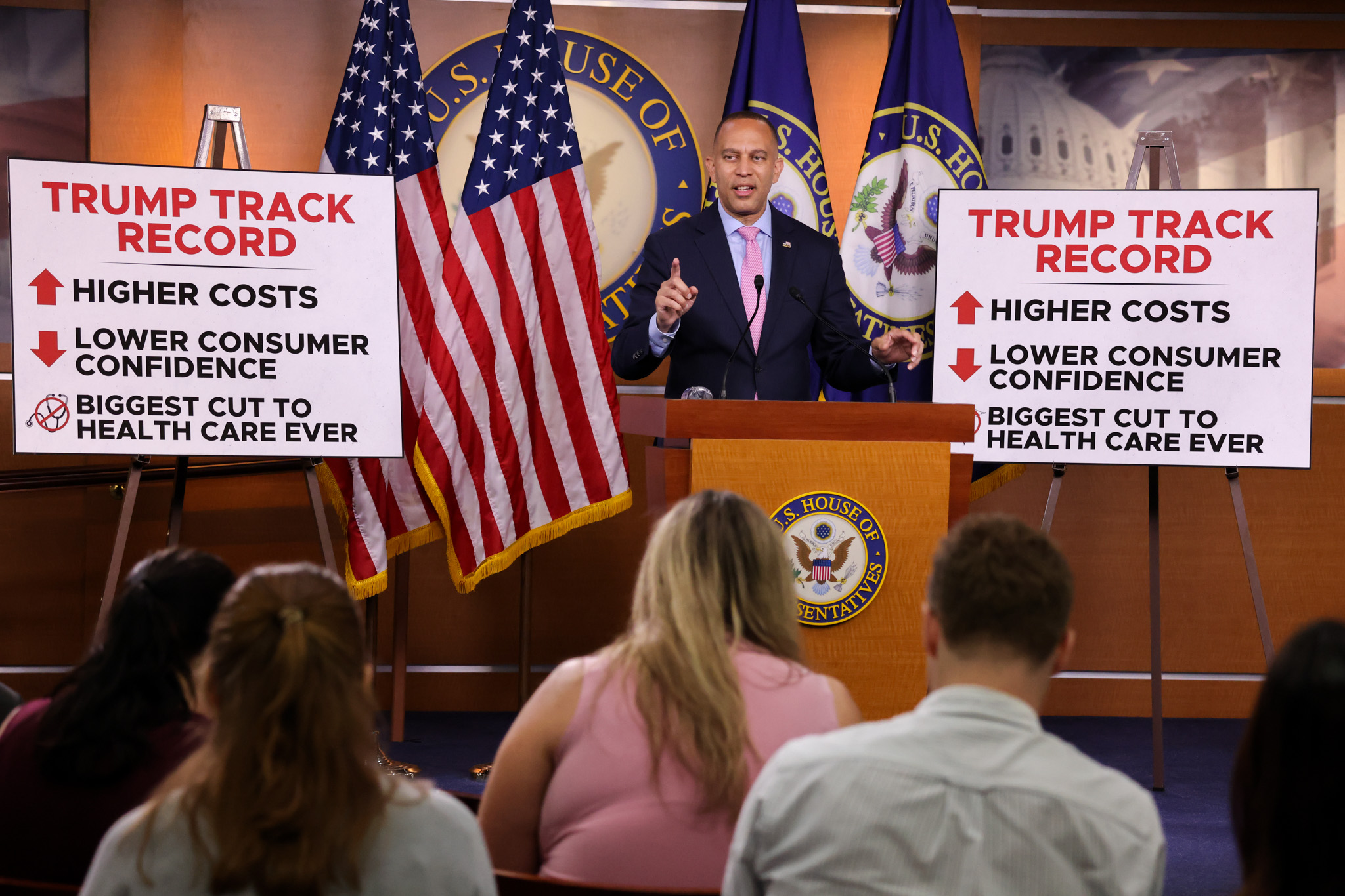 Leader Jeffries Speaking at Weekly Press Conference in between signs that read "Higher Costs; Lower Consumer Confidence; Biggest Cut to Health Care Ever"