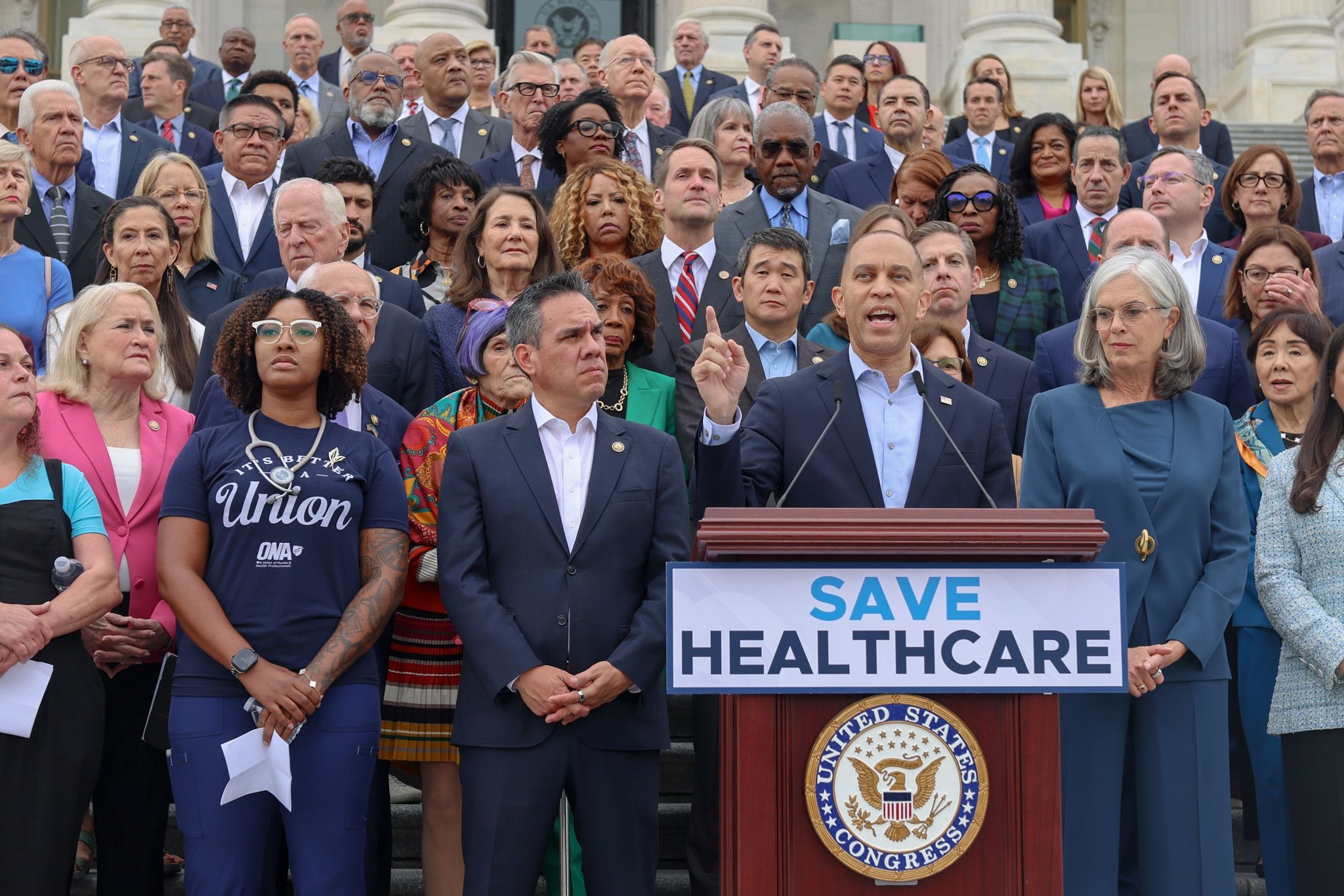 Leader Jeffries (center), Whip Katherine Clark (right) and Chair Pete Aguilar (left) speaking on the House steps, in front of House Democrats