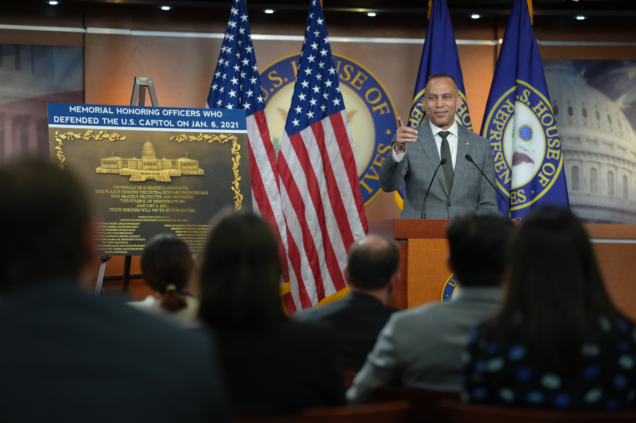Leader Jeffries Speaking at Weekly Press Conference with a Poster of Plaque Honoring Police Officers who Defended the Capitol on January 6