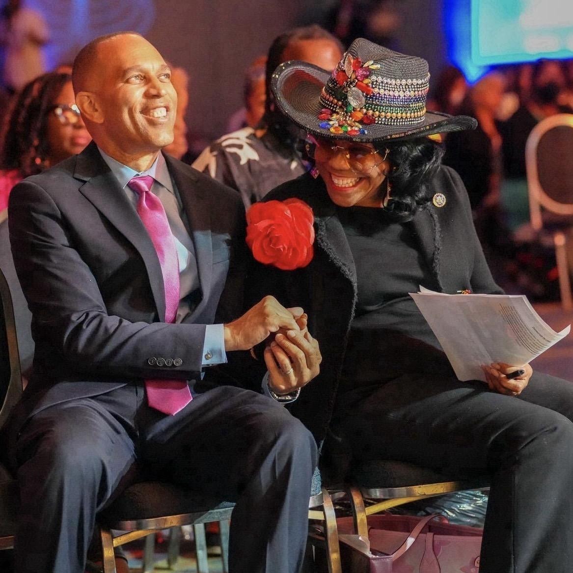 Leader Jeffries and Rep. Frederica Wilson smiling and holding hands while seated