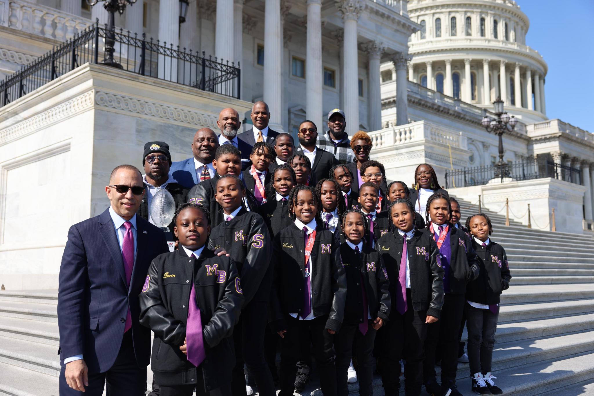Leader Jeffries posing on House steps with members of the Mo Better Jaguars football team