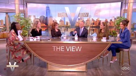 Hosts of The View (Whoopi Goldberg, Sara Haines, Joy Behar, Sunny Hostin and Alyssa Farah Griffin)and Leader Jeffries sitting at a wooden table with the words "The View" displayed
