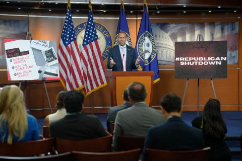 Leader Jeffries Speaking at Weekly Press Conference with a poster reading 'Project 2025: Criminalize Abortion, Hurt The Middle Class, End Social Security' and 'Republican Shutdown'